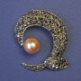 Broche «Acento» con perla marrón y strass grises, 45×48 mm ±, de metal bronce